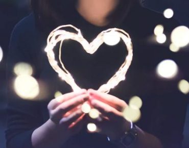 Person holding heart symbol